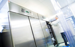 Vials being placed in pharmaceutical product development refrigeration units