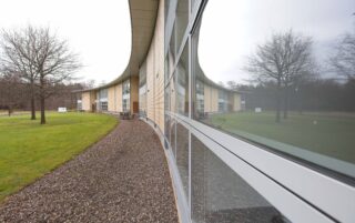 Picture of Symbiosis Pharmaceutical Services curved building with tree reflection